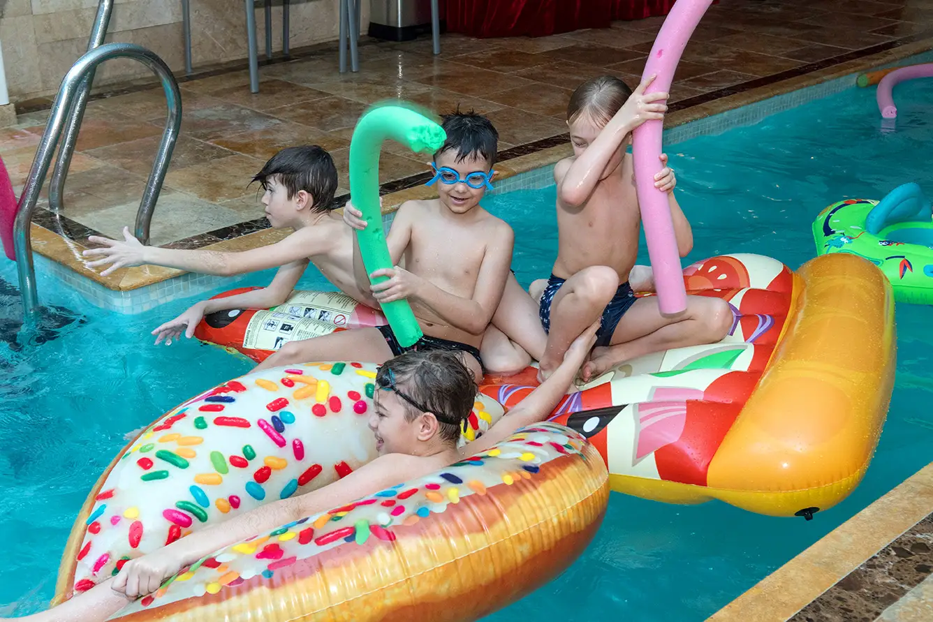 Copii pe colaci gonflabili în piscina interioară Luxuria Centrum